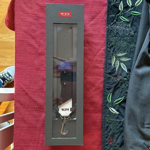 New in box Tumi leather strap- never removed from box - box has small damage